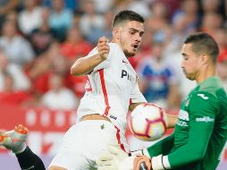 El delantero del Sevilla, André Silva, remata frente al arquero Sergio, quien se queda con el balón. AFP