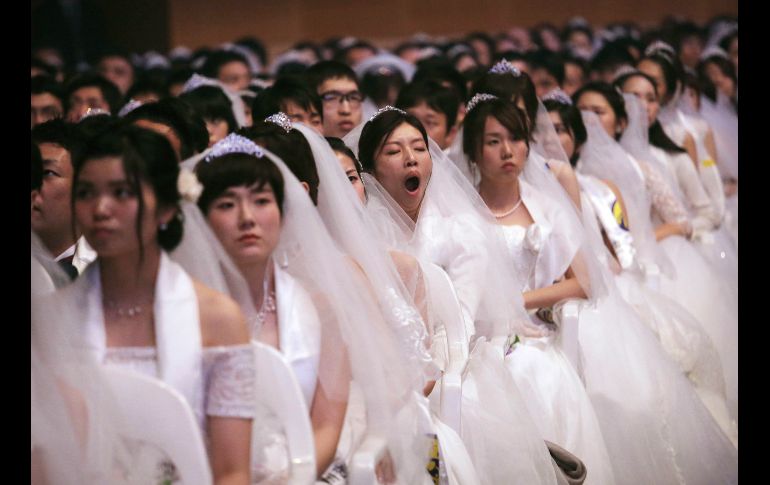 Una novia bosteza durante una boda masiva en Gapyeong, Corea del Sur. Parejas locales y extranjeras intercambiaron votos en la ceremonia de la Iglesia de la Unificación. AP/ Ahn Young-joon
