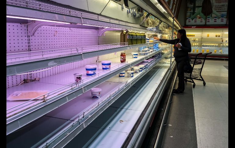 Personas buscan productos en un supermercado en Caracas, Venezuela. Tras casi una semana de que el Gobierno del presidente Nicolás Maduro fijara los precios de al menos 25 alimentos de la canasta básica, se observa la desaparición casi total de estos productos. EFE/M. Gutiérrez