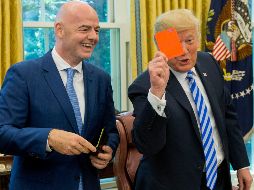 El presidente de los Estados Unidos, Donald J. Trump (d), sostiene una tarjeta roja que tiene su nombre escrito, junto al presidente de la FIFA, Gianni Infantino. EFE/M. Reynolds