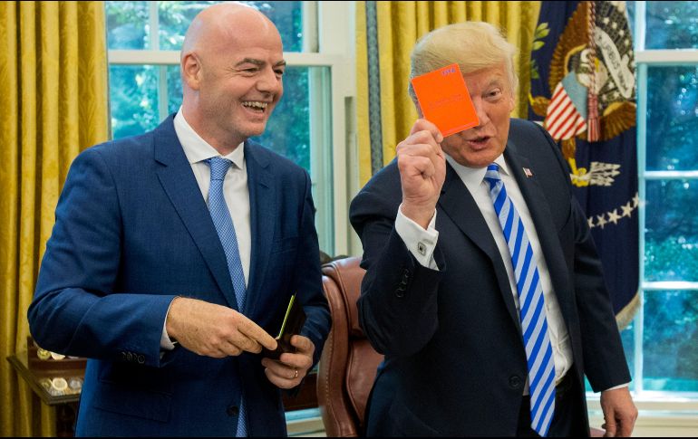 El presidente de los Estados Unidos, Donald J. Trump (d), sostiene una tarjeta roja que tiene su nombre escrito, junto al presidente de la FIFA, Gianni Infantino. EFE/M. Reynolds
