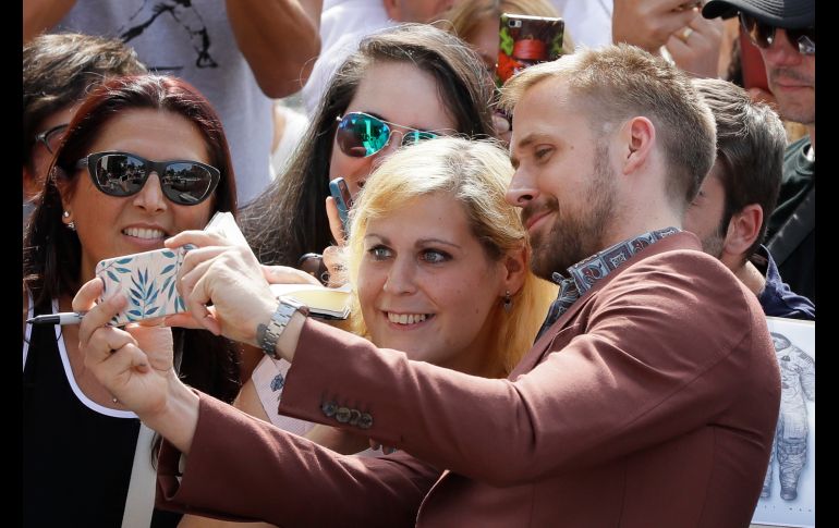 El actor Ryan Gosling posa para fotos con fans a su llegada a un pase para prensa de la película 