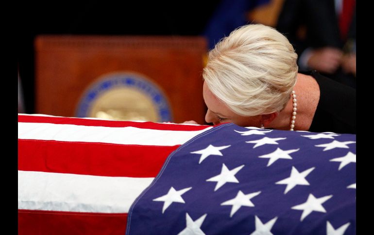 Cindy McCain se apoya en el féretro con los restos de su esposo, el senador estadounidense John McCain, durante una ceremonia en la rotonda del Capitolio de Arizona, en Phoenix. AP/J. Hong