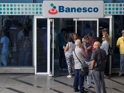 Venezolanos esperan en bancos y supermercados, que cerraron por el apagón, para esperar a que abran y sacar efectivo. EFE / M. Gutiérrez