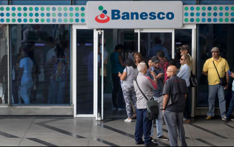 Venezolanos esperan en bancos y supermercados, que cerraron por el apagón, para esperar a que abran y sacar efectivo. EFE / M. Gutiérrez