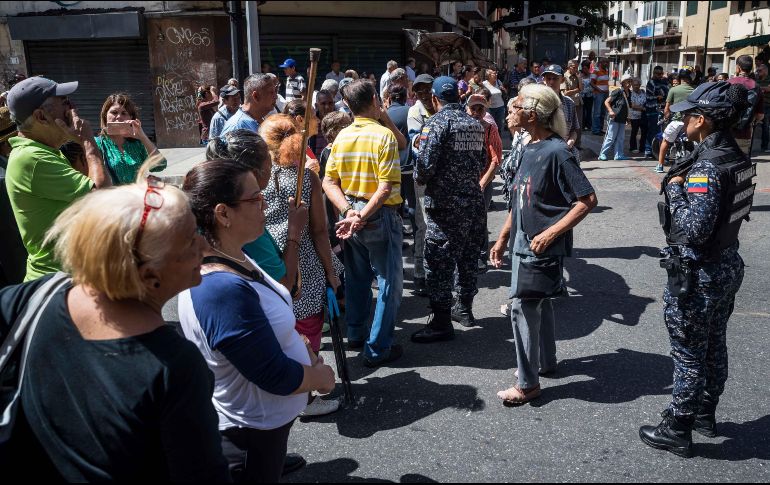Adultos mayores protestan frente a integrantes de la Policía Nacional Bolivariana. EFE/. Gutiérrez