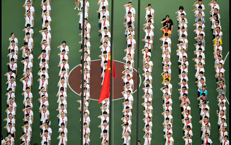 Niños se forman en una ceremonia de honores a a la bandera, en el primer día del ciclo escolar en una escuela en Shanghái, China. AFP/J. Eisele