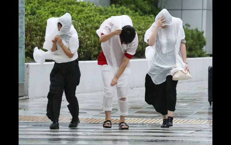 Personas caminan contra fuertes vientos en Nagoya. AFP/JIJI PRESS