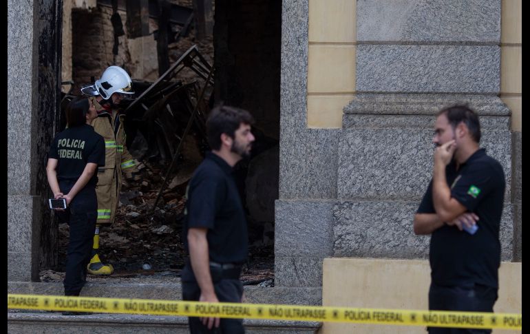 Policías y un bombero trabajan en el Museo Nacional de Río de Janeiro, en Brasil. Un incendio devoró el domingo el sitio, que contaba con un acervo de unas 20 millones de piezas. AFP/M. Pimentel