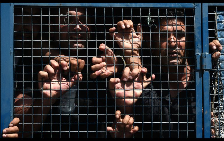 Maestros cachemires gritan consignas contra el gobierno en un vehículo policial, tras ser arrestados en una protesta en Srinagar, India. La policía detuvo a decenas de profesores que pedían incremento salarial y la regularización de su trabajo. AFP/T. Mustafa