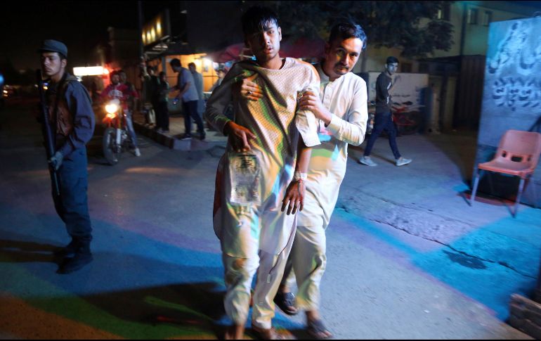 Un herido es ayudado por un voluntario, quien lo lleva a las afueras de un hospital. AP/R. Gul