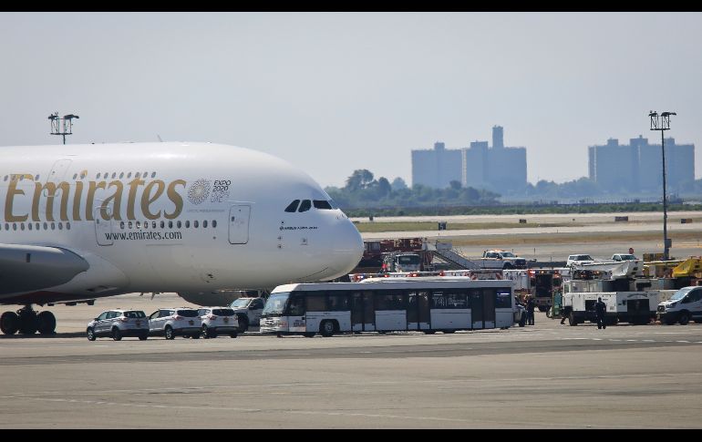Personal de emergencias se congrega afuera de un avión procedente de Dubái en el aeropuerto JFK de Nueva York, Estados Unidos. El avión  fue puesto en cuarentena con varios centenares de personas a bordo, después de que 19 personas se sintieran enfermas, según informó la Alcaldía. AP/B. Matthews