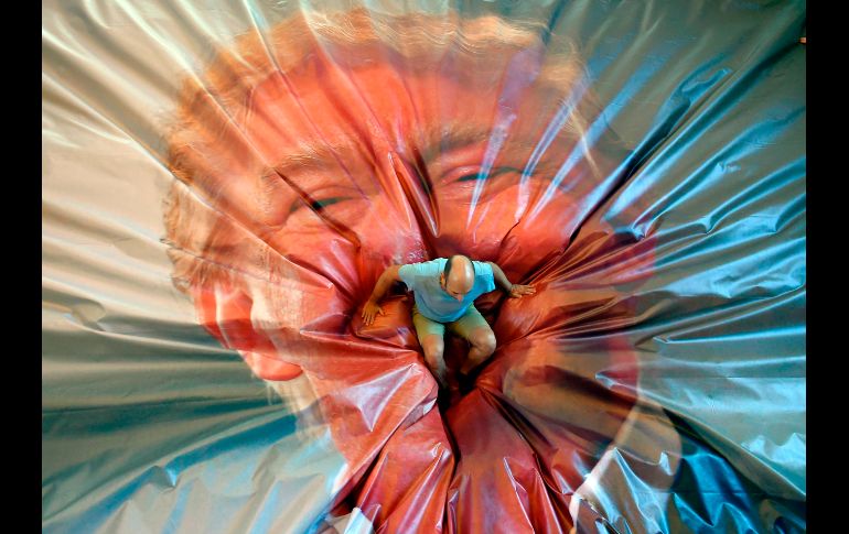 Un visitante a Getxophoto se ve tras caer sobre la imagen del presidente de Estados Unidos.