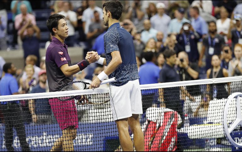 Novak Djokovic y Kei Nishikori estrechan sus manos después del juego. EFE/J. Maganblo