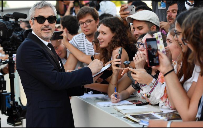 Alfonso Cuarón firma autógrafos poco antes de entrar a la ceremonia de premiación. EFE/E. Ferrari