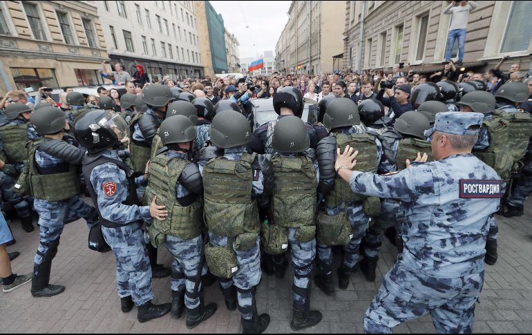 Los agentes de policía se pelean con los manifestantes mientras intentan bloquearlos. EFE / A. Maltsev