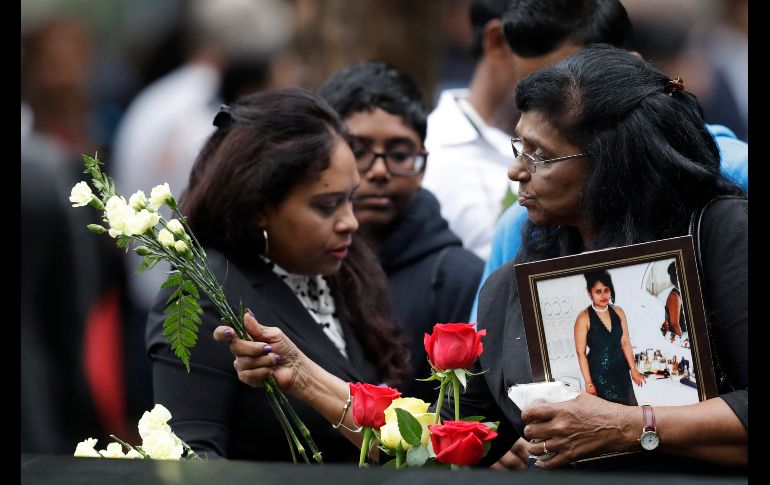 Una mujer coloca flores en una ceremonia por las víctimas de los atentados del 11 de Septiembre en  Nueva York, Estados Unidos. AP/M. Lennihan