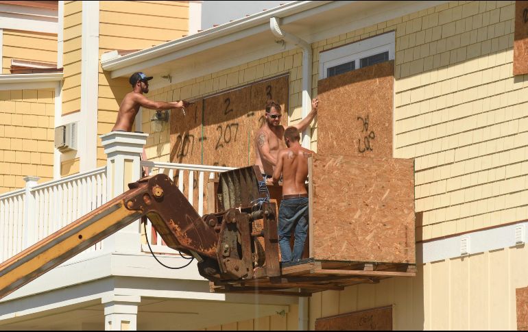 Ciudadanos refuerzan sus casas en Carolina del Norte. AP/K. Blevins
