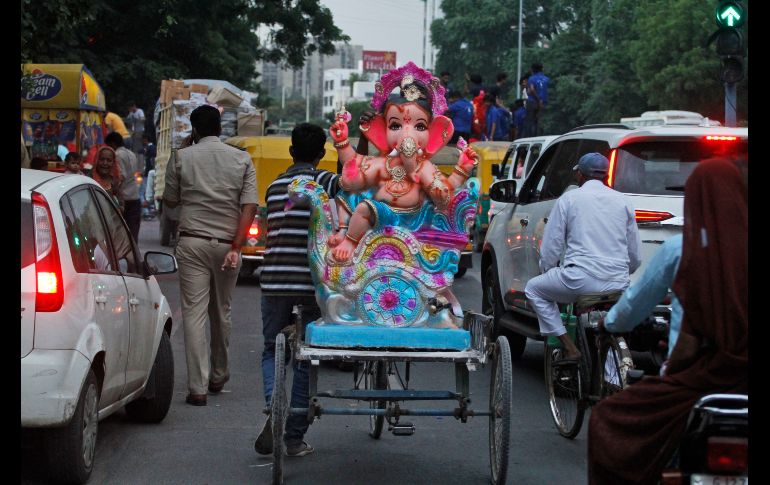 Un hombre transporta una imagen del dios hindú Ganesha, con cabeza de elefante, en la víspera de un festival en honor del dios en Ahmadabad, India. AP/A. Solanki