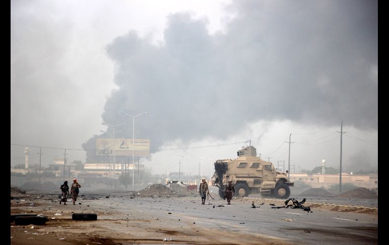 Miembros de las fuerzas gubernamentales yemeníes patrullan mientras ascienden columnas de humo de una presunta posición hutí, durante la lucha entre el gobierno yemení y los rebeldes hutíes en el frente de Al Hudeida, Yemen. EFE/N. Almahboobi