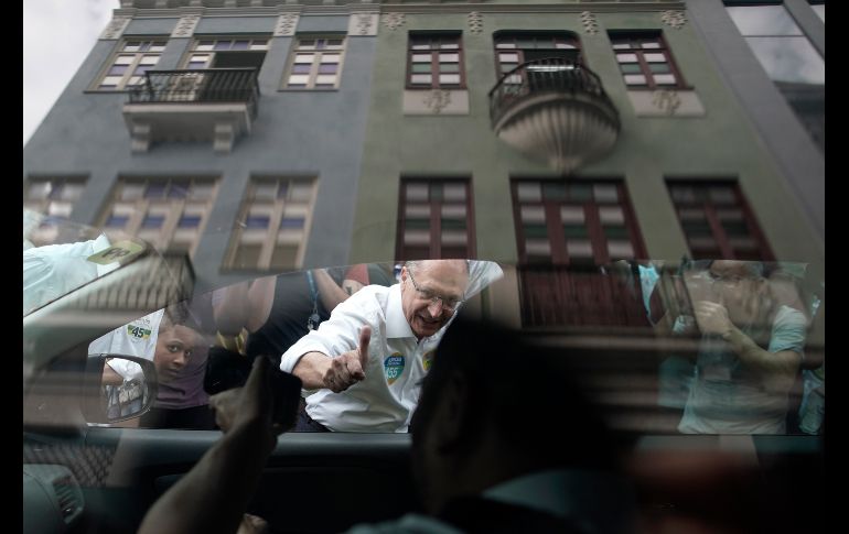 Geraldo Alckmin, candidato presidencial del partido Social Demócrata, saluda a un taxista mientras hace campaña en el centro de Río de Janeiro, Brasil. AP/L. Correa