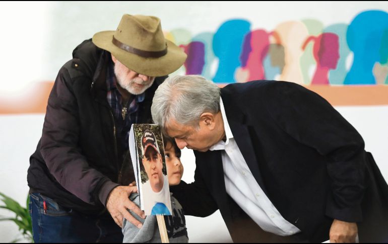El escritor y activista Javier Sicilia y Andrés Manuel López Obrador saludan a un niño que muestra la fotografía de su padre desaparecido. EFE