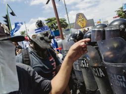 Inconformes encaran a policías en una marcha denominada “Juntos somos patria”, en Managua. EFE
