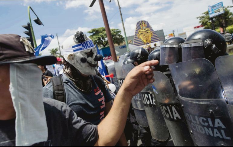 Inconformes encaran a policías en una marcha denominada “Juntos somos patria”, en Managua. EFE