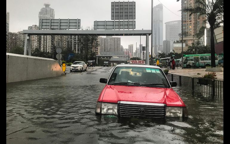 Un taxi luce abandonado en una calle inundada en Hong Kong.