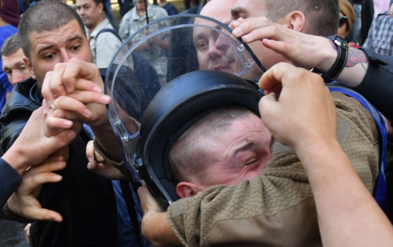 Activistas de grupos de ultra derecha se enfrentan con policías frente a la oficina del procurador general en Kiev, Ucrania, durante una protesta contra la extradición a Rusia de un presunto miembro del grupo Estado Islámico que habría luchado contra los rebeldes separatistas en el este del país. AFP/S. Supinsky