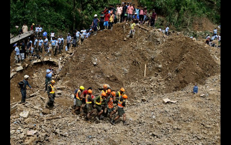 Rescatistas trasladan un cuerpo que recuperaron tras un alud en Itogon, Filipinas, provocado por el paso del tifón 