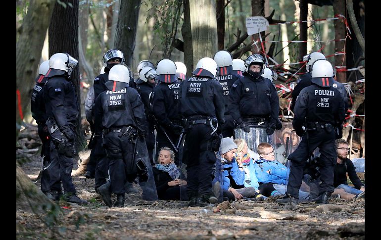 Policías rodean a manifestantes cerca de Kerpen, Alemania, durante la evacuación del campamento de ambientalistas que protestan por la deforestación de partes del bosque Hambacher por las obras de compañía de energía RWE. AFP/DPA/O. Berg