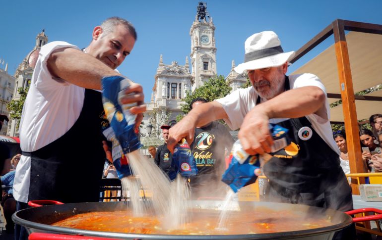 Una pareja de cocineros echa el arroz a la paella durante la celebración del Día Mundial de la Paella, que pretende dar prestigio a uno de los platos más conocidos de la gastronomía de todo el mundo y proyectar la ciudad de Valencia, España, como destino turístico internacional. EFE/K.Försterling