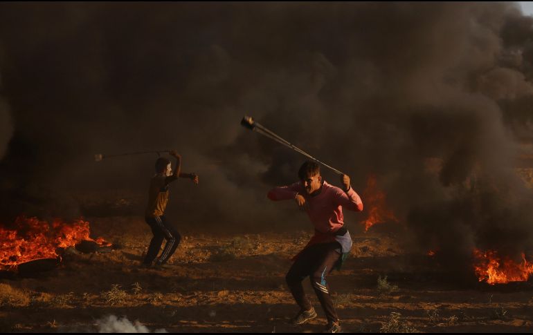 Manifestantes lanzan piedras contra los uniformados israelíes en la frontera de Gaza. AP/A. Hana