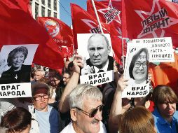 Comunistas portan retratos de Putin y otros altos mandos rusos con el lema “Enemigo del pueblo”. EFE