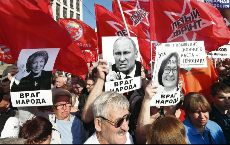 Comunistas portan retratos de Putin y otros altos mandos rusos con el lema “Enemigo del pueblo”. EFE