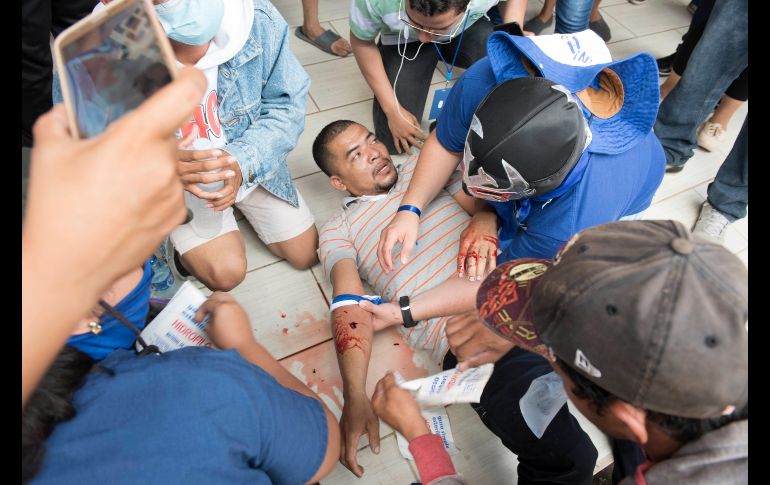 Personas auxilian en un templo a un manifestante herido.