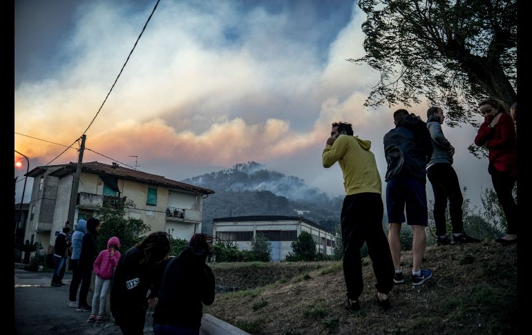 Habitantes observan un incendio en montañas de Calci, en la región italiana de la Toscana. Cientos de personas evacuaron sus casas ante el avance del fuego. AFP/F. Scoppa