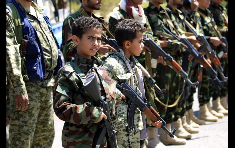 Niños acompañados de sus padres sostienen armas durante una reunión en Saná, Yemen, en apoyo a al movimiento chiíta contra la intervención liderada por Arabia Saudí. AFP/M. Huwais
