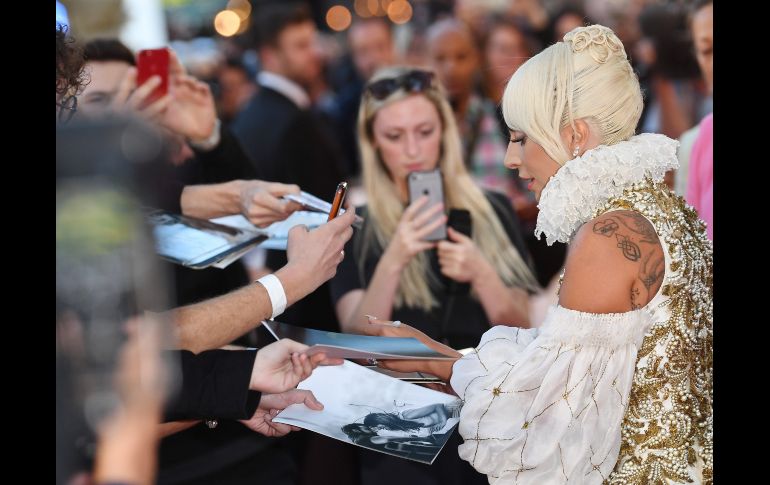 La actriz y cantante estadounidense Lady Gaga firma autógrafos a su llegada a la presentación de la película 