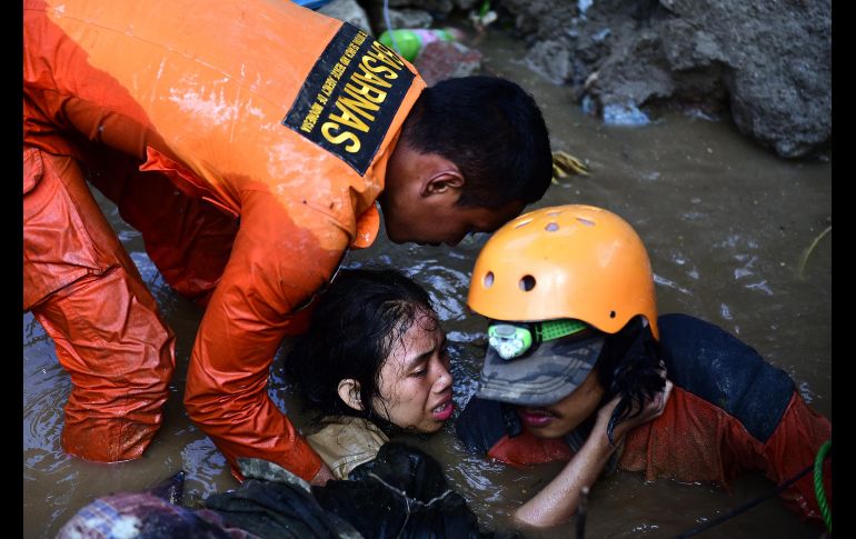 Integrantes de los servicios de rescate tratan de salvar a la joven Nurul Istikhomah de las ruinas inundadas de su casa en Palu.