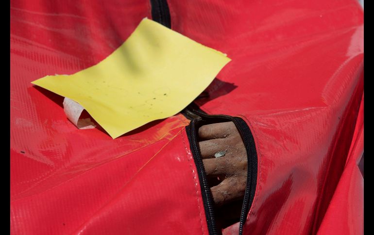 La mano de una víctima se ve dentro de una bolsa para cadáveres en un hospital de la policía.