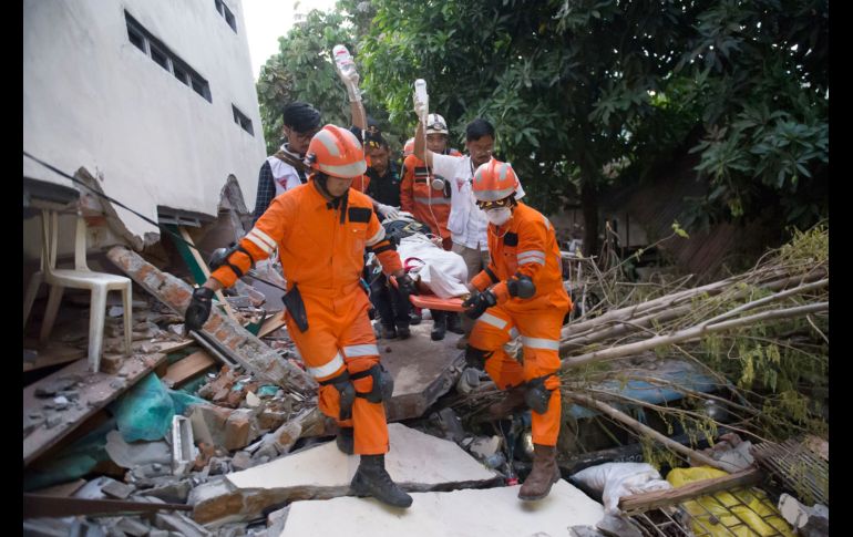 Rescatistas sacan a una sobreviviente de entre los escombros de un restaurante en Palu, Indonesia, el cual colapsó tras el sismo del viernes.