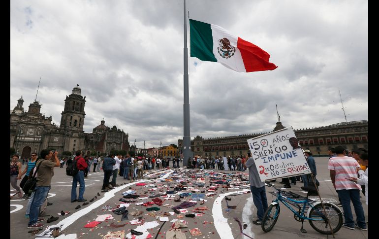 Activistas hicieron una pinta en el Zócalo y colocaron ropa, zapatos y otros artículos manchados de pintura roja, simulando la sangre y los objetos que cubrieron la Plaza de las Tres Culturas tras la masacre.