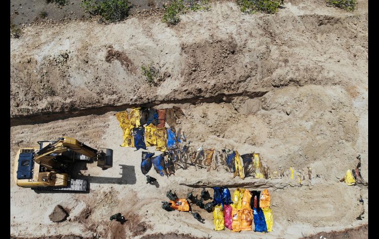 Soldados entierran a víctimas de los fenómenos naturales en una fosa masiva en Poboya. AFP/J. Samad