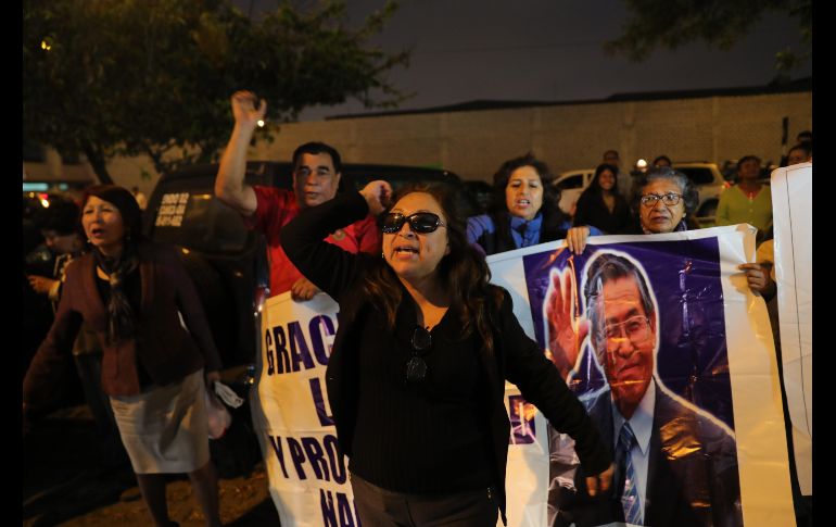 Seguidores del expresidente peruano Alberto Fujimori gritan consignas afuera de una clínica donde fue internado en Lima. Fujimori ingresó antes de que las autoridades ejecuten la orden de captura que pesa sobre él, en cumplimiento a la sentencia que anula el indulto a la condena de 25 años de prisión. EFE/E. Arias