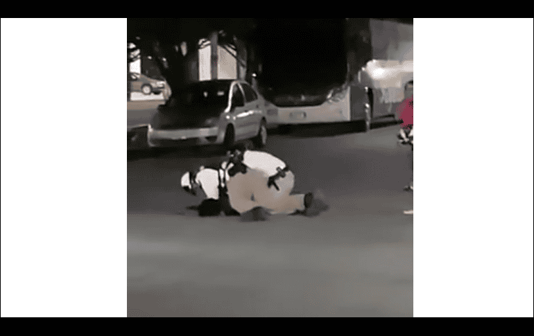 En la imagen se aprecia que en el intento por detenerlo, el par de agentes lo golpean mientras el joven pone resistencia. YOUTUBE / IQCANCUN Diana Alvarado