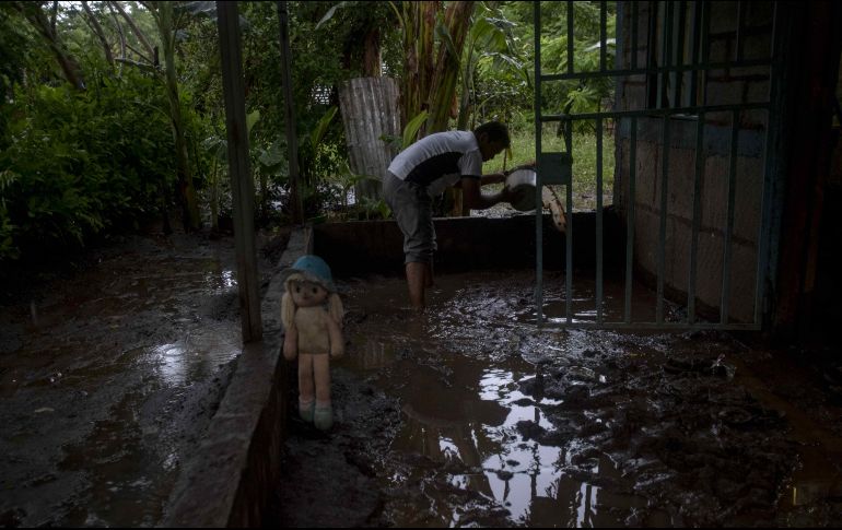 Un hombre saca el agua de su casa, afectada por las tormentas. EFE/J. Torres