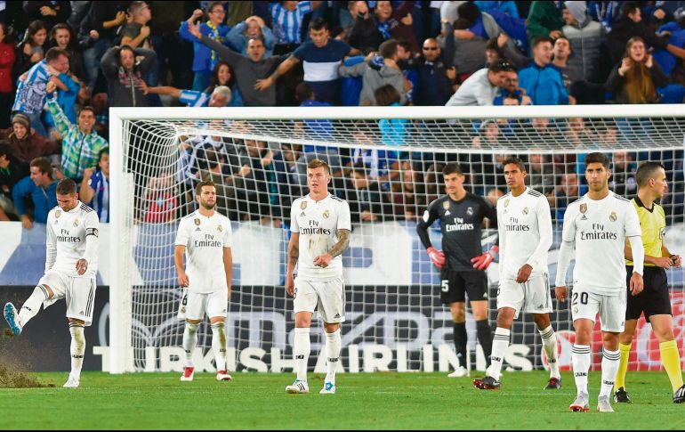 Sergio Ramos patea el césped tras consumarse la derrota madridista, mientras sus compañeros caminan tristes. AFP