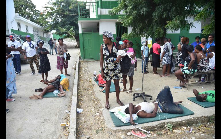 Personas heridas reciben atención en el patio de un hospital en la ciudad de Port-de-Paix.